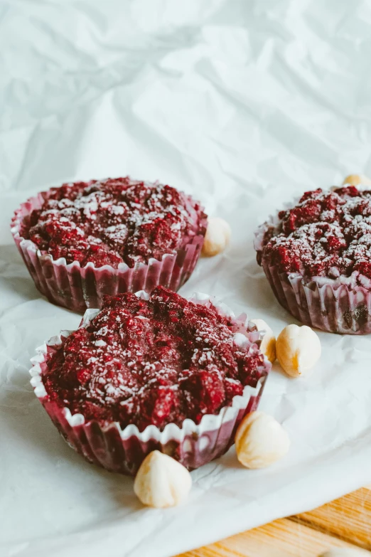 three muffins sitting on top of a piece of paper, pexels, dressed in red velvet, rocky roads, medium wide front shot, fruit