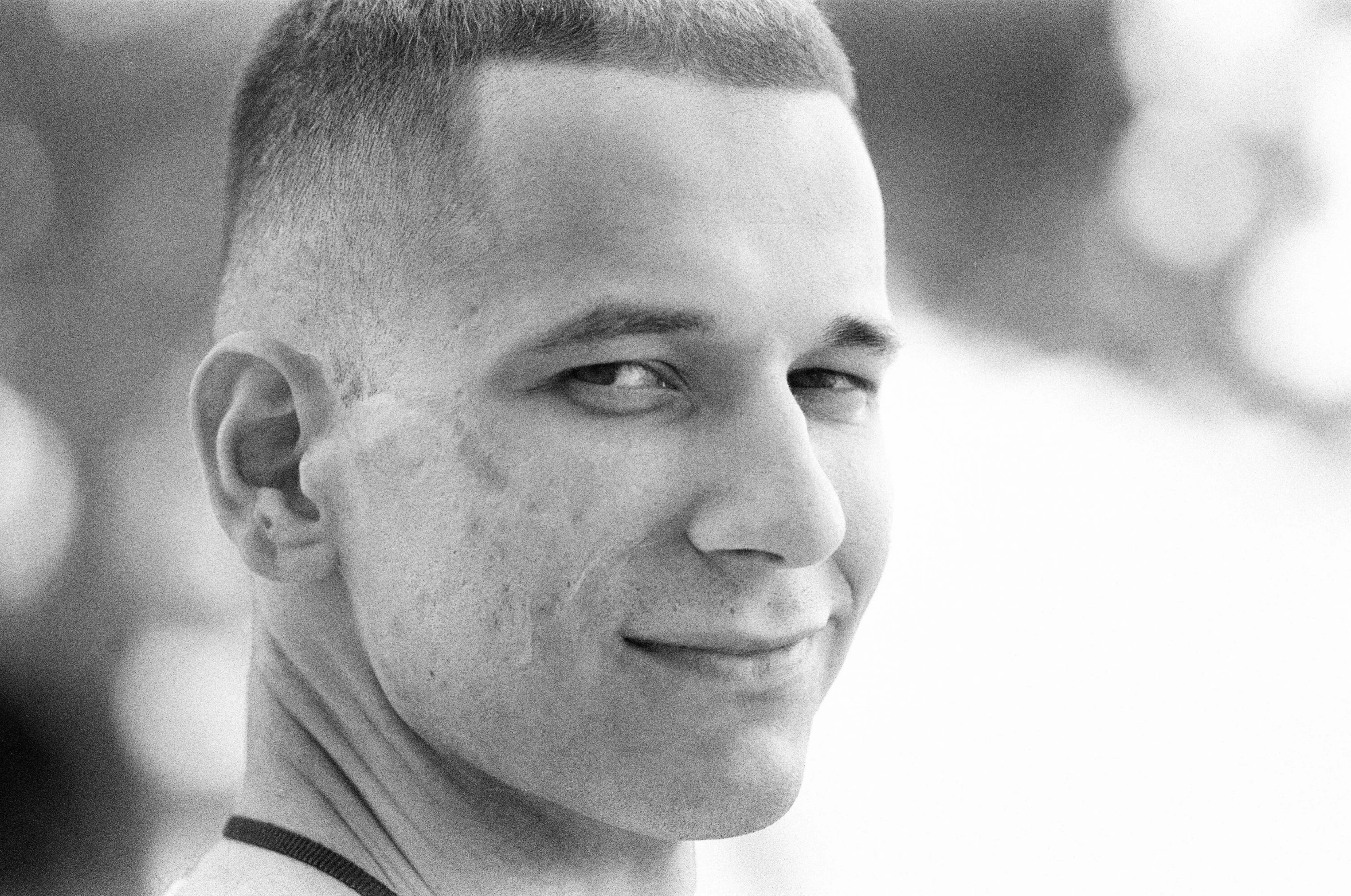 a black and white photo of a man smiling, a black and white photo, by Jan Rustem, pixabay, buzz cut hair, white american soldier, karim rashid, 1999 photograph