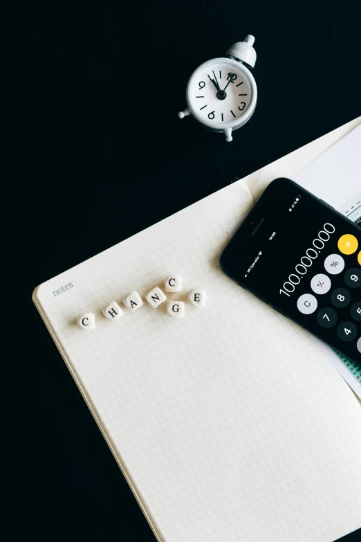 a cell phone sitting on top of a notebook next to a calculator, trending on pexels, bling, black and yellow scheme, 000 — википедия, knolling