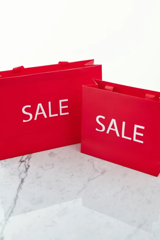two red shopping bags with sale written on them, by Arabella Rankin, high gloss, 3 - piece, large format, f / 1