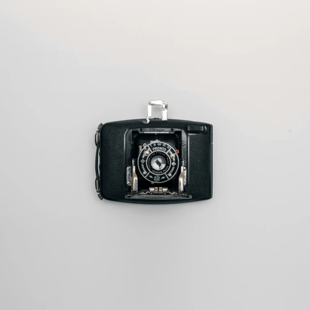 a close up of a camera on a white surface, by Jan Kupecký, unsplash, visual art, close up shot of an amulet, black color on white background, vintage color, medium format