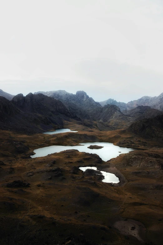 a body of water surrounded by mountains on a cloudy day, a matte painting, by Lucas Vorsterman, trending on unsplash, minimalism, helicopter view, ponds, peruvian looking, skye meaker