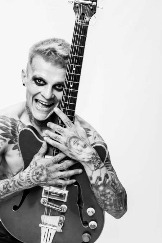 a man with tattoos holding a guitar, an album cover, inspired by Seb McKinnon, antipodeans, nikola jokic as the joker, vesa-matti loiri, die antwoord, uploaded