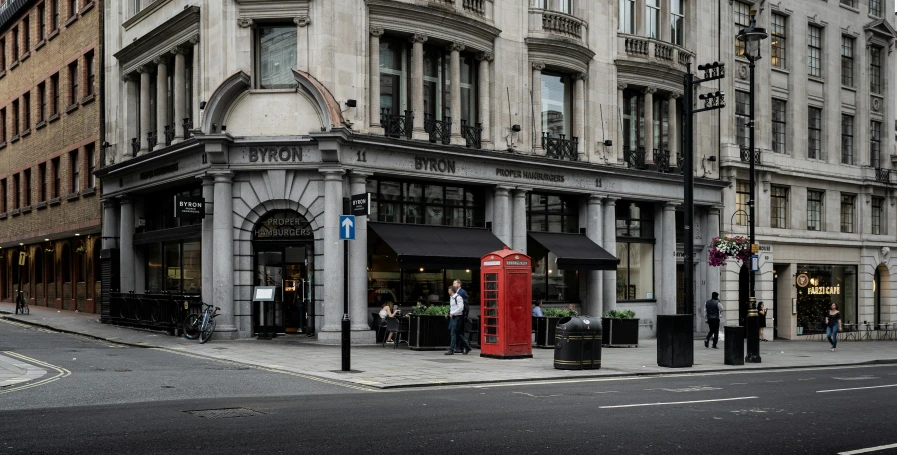 a red phone booth sitting on the side of a street, by Tom Bonson, pexels contest winner, art nouveau, concept art | dyson, restaurant exterior photography, square, anor londo