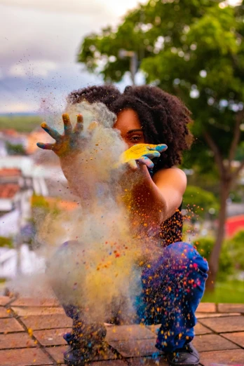 a woman throwing colored powder into the air, jamaican colors, desaturated colors, promo image, colorful]”