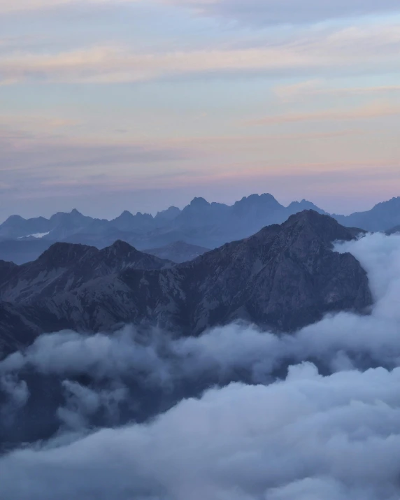 a group of people standing on top of a mountain, by Sebastian Spreng, pexels contest winner, romanticism, pink and grey clouds, panoramic view, predawn, seen from a plane