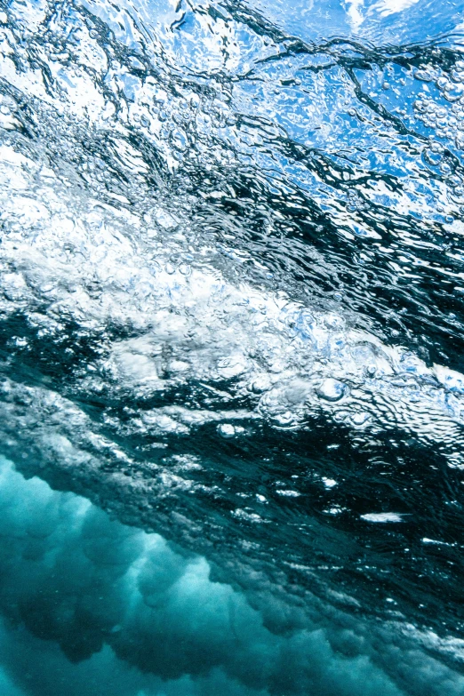 a man riding a wave on top of a surfboard, an album cover, trending on unsplash, underwater crystals, full frame image, water bubble, shades of blue