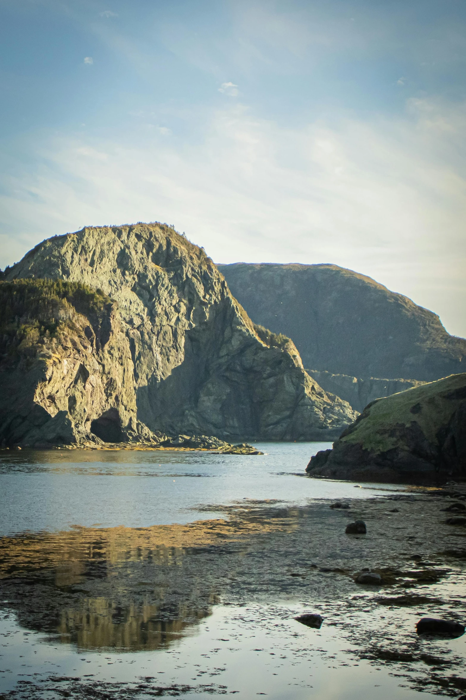 a body of water with a mountain in the background, les nabis, coastal cliffs, high sharpness, rock arcs, beautifully lit