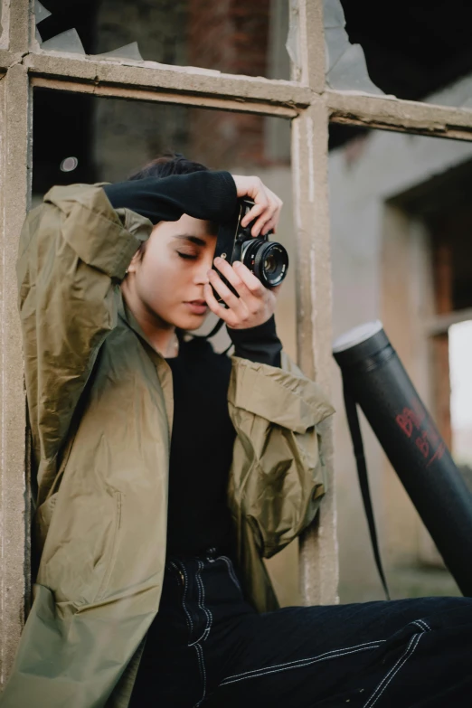 a woman taking a picture with a camera, inspired by Elsa Bleda, trending on pexels, visual art, wearing military outfit, portrait sophie mudd, androgynous person, photograph of a techwear woman