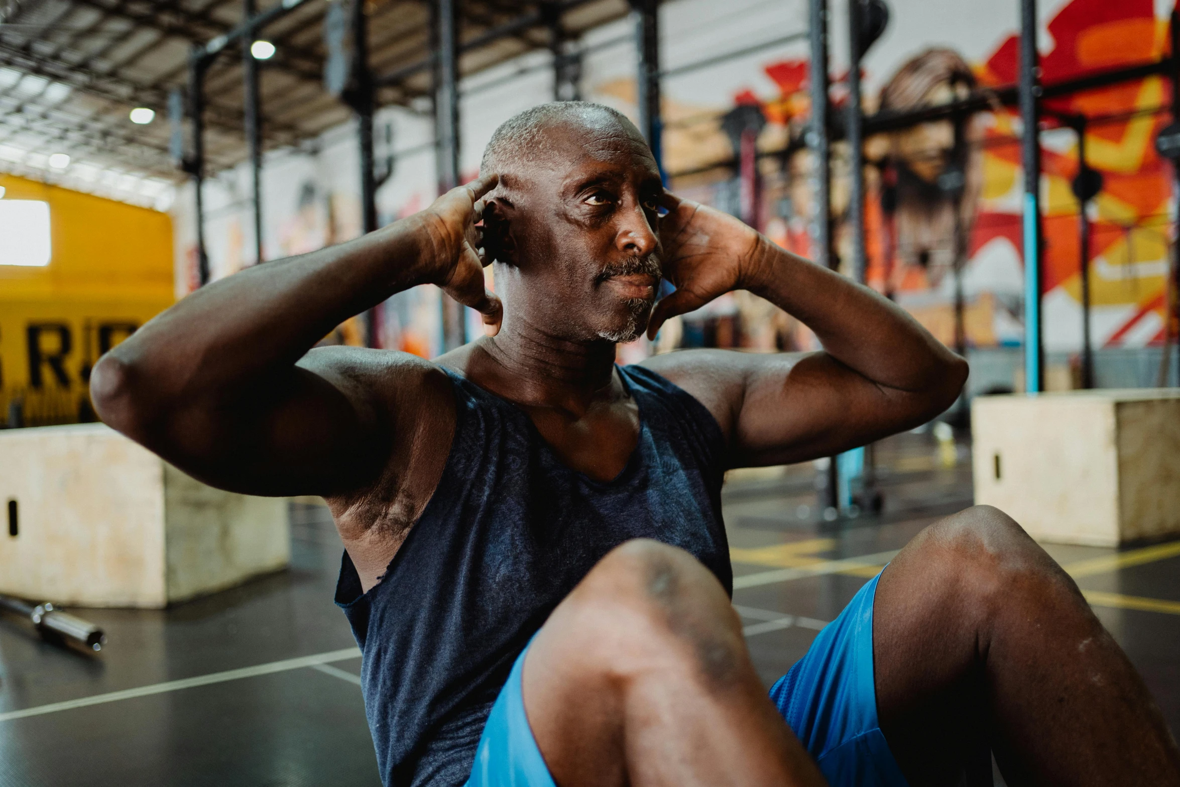a man sitting on the ground talking on a cell phone, a portrait, pexels contest winner, hyperrealism, background a gym, man is with black skin, sweating hard, avatar image