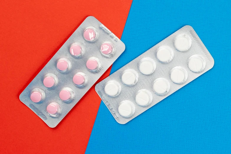 a couple of contrails sitting next to each other on a blue and red background, inspired by Damien Hirst, antipodeans, pills, close-up product photo, white and pink cloth, medical labels