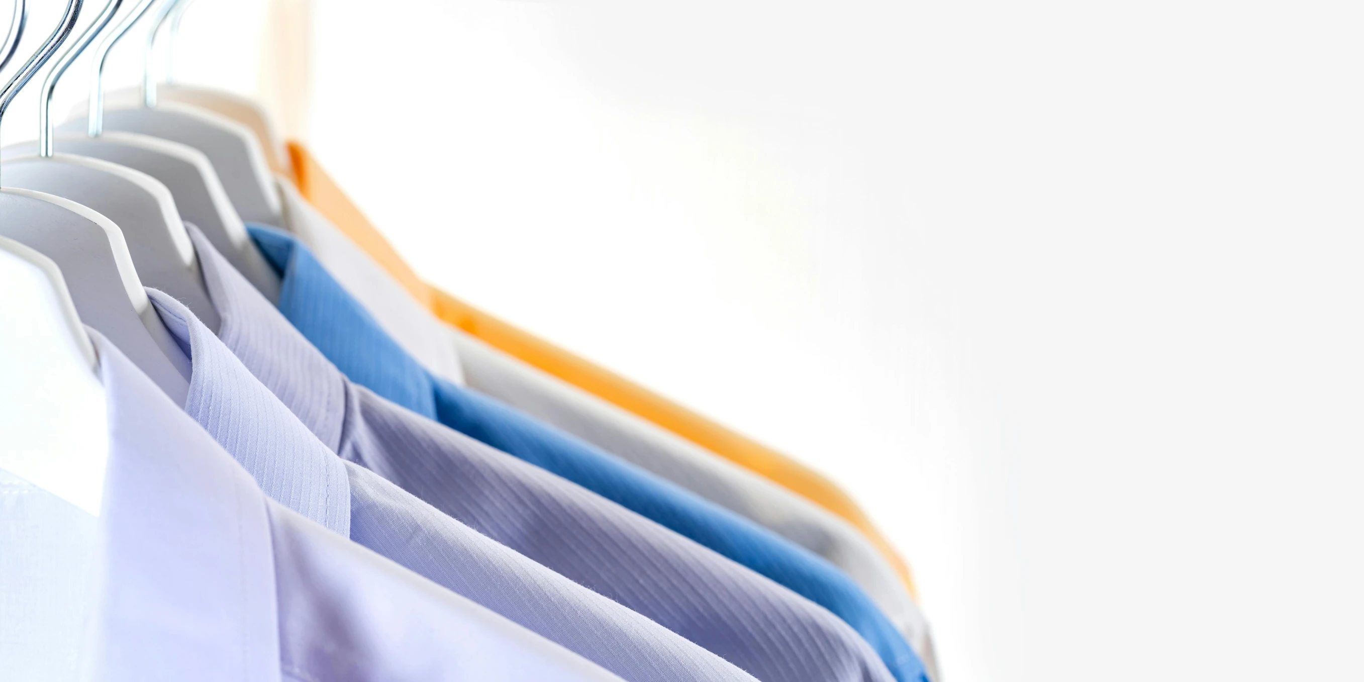 a row of shirts hanging on a clothes rack, by Daniel Gelon, plasticien, sterile colours, thumbnail, ultra fine details, some orange and blue