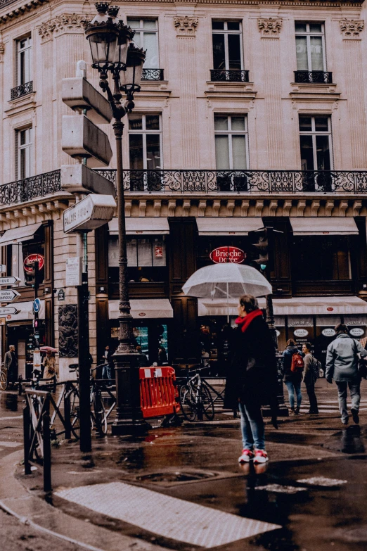 a person holding an umbrella on a city street, pexels contest winner, paris school, low quality photo, storefronts, square