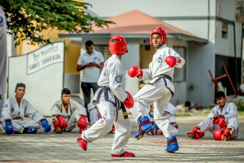 a couple of men standing next to each other on a field, a colorized photo, by Daryush Shokof, pexels contest winner, academic art, karate kick, battle action shot, malayalis attacking, thumbnail