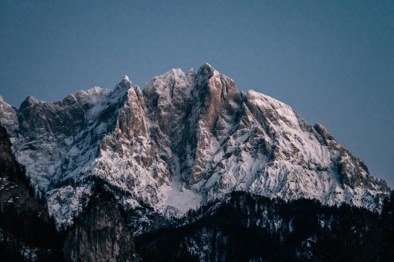 the top of a mountain covered in snow, pexels contest winner, rugged face, low light, 4 k hd wallpapear, viewed from a distance