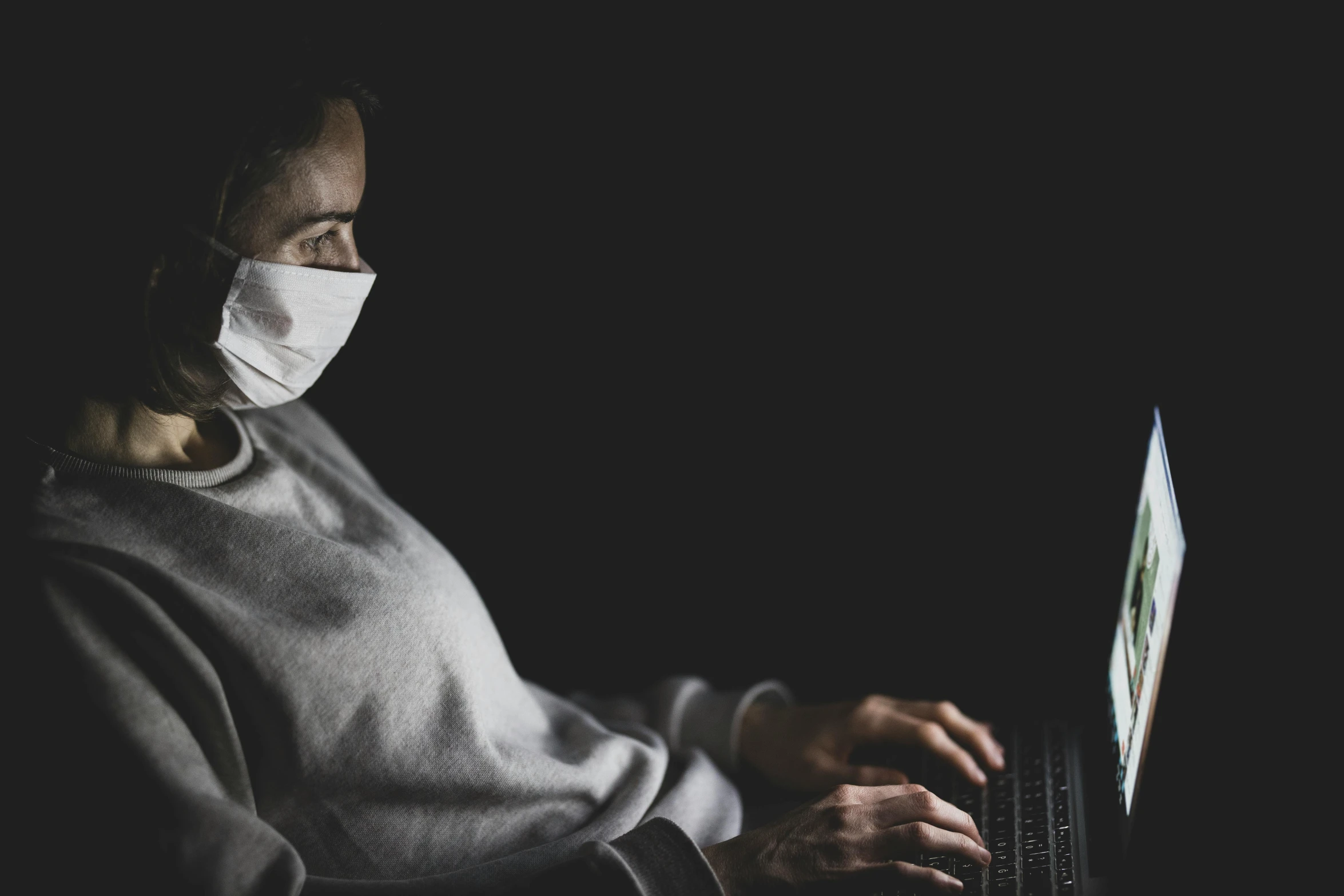 a woman wearing a face mask using a laptop, by Adam Marczyński, low key, sickness, instagram picture, pixar coronavirus movie