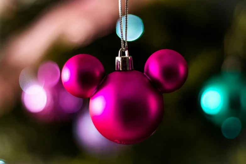 a mickey mouse ornament hanging from a christmas tree, inspired by disney, pexels, magenta colours, closeup - view, wide, josh grover