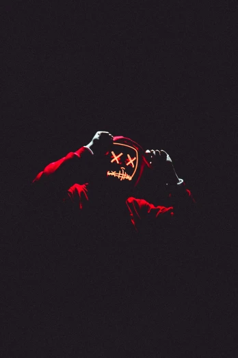 a person wearing a mask in the dark, an album cover, by Bascove, 256x256, hq 4k phone wallpaper, red, halloween