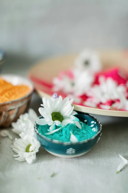 a table topped with bowls of food and flowers, turqouise, spa, pigment, medium close shot