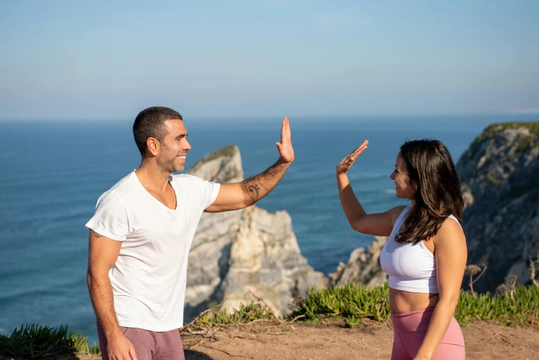 a man and a woman giving each other a high five, by Dan Content, pexels contest winner, nazare (portugal), yoga, background image, avatar image