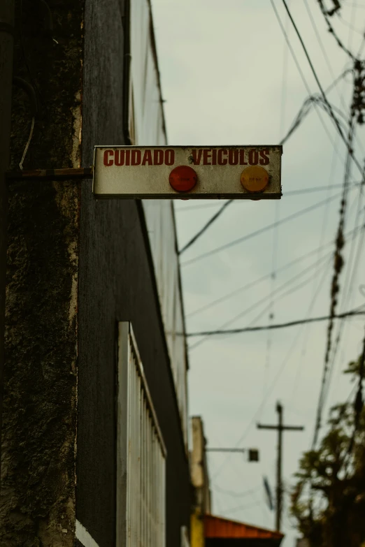 a street sign hanging from the side of a building, by Elsa Bleda, unsplash, in chuquicamata, low quality photo, historical photo, traffic lights