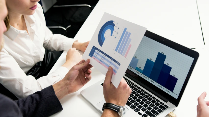 a couple of people sitting at a table with a laptop, trending on unsplash, analytical art, informative graphs and diagrams, 15081959 21121991 01012000 4k, medium closeup, low quality photo