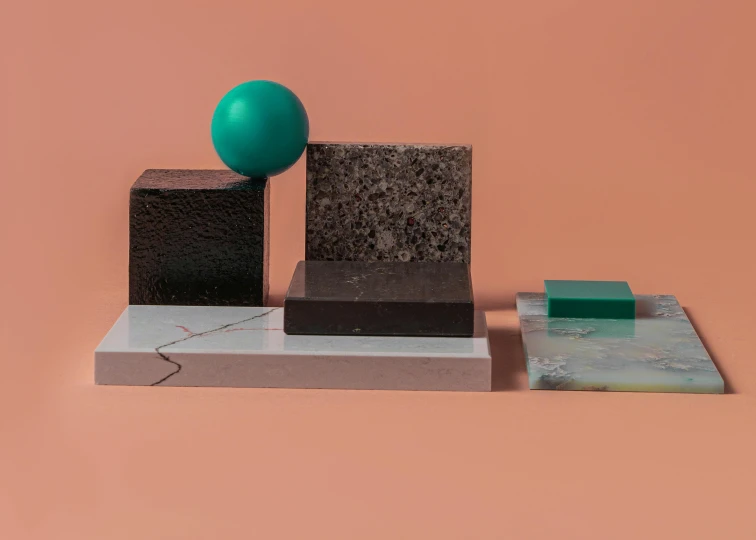 a green ball sitting on top of a block, an abstract sculpture, inspired by Bauhaus, new sculpture, silicon and carbon, rectangle, while marble, black and teal paper