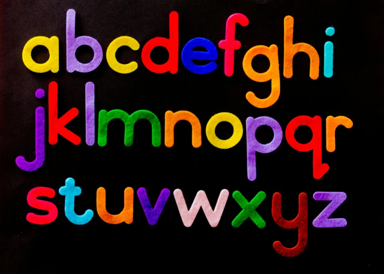 a close up of a colorful alphabet on a black background, pexels, fan favorite, felt, teaching, full - view