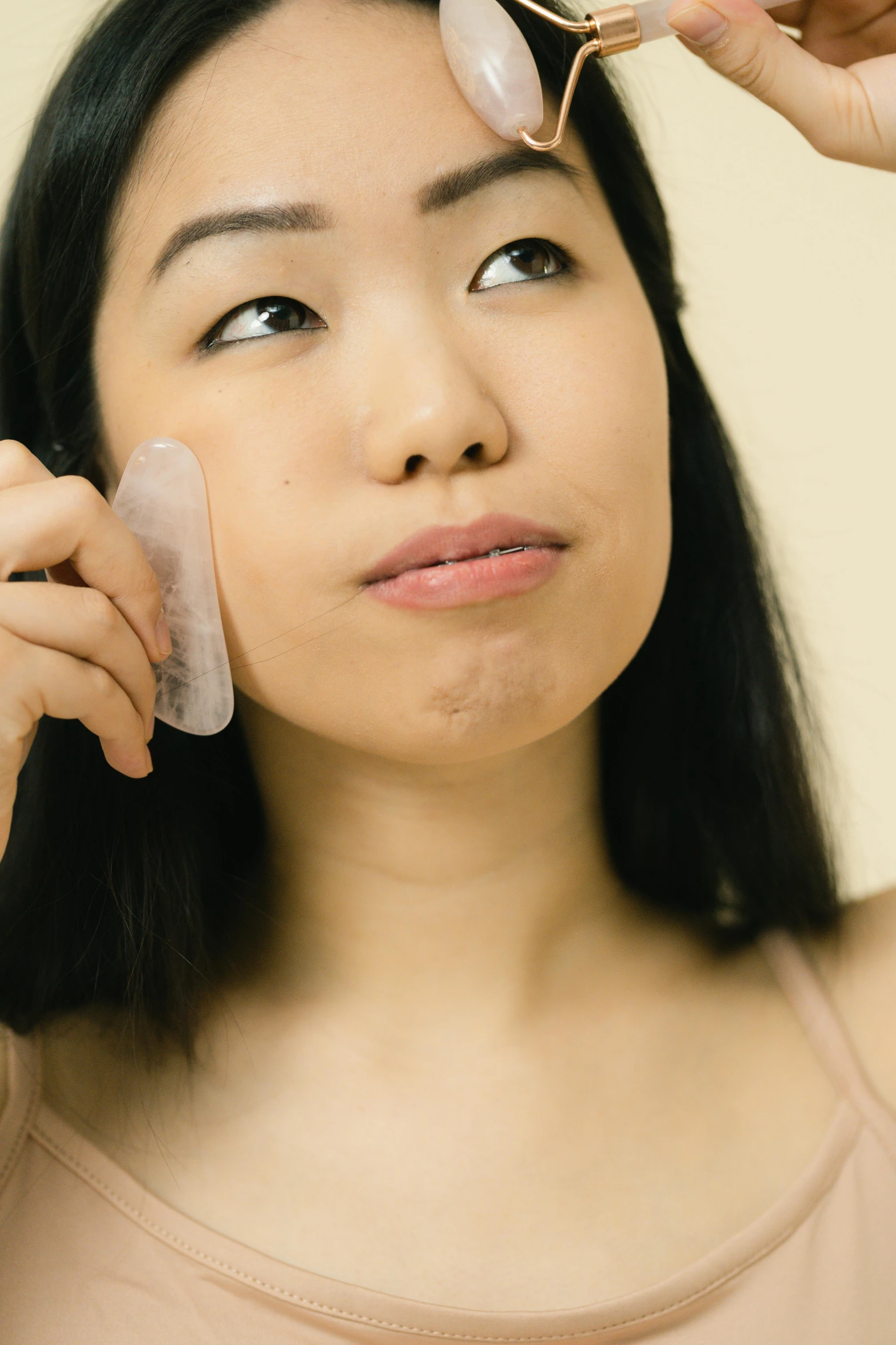 a woman brushing her hair in front of a mirror, an album cover, trending on pexels, mingei, facial scar, wearing translucent sheet, detailed product image, asian face