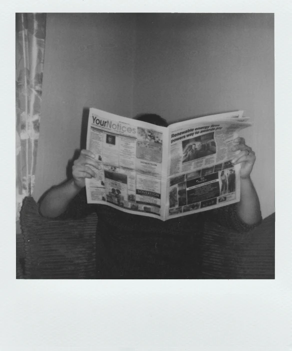 a black and white photo of a man reading a newspaper, inspired by Arnold Newman, happening, polaroid colour faded, ( ( photograph ) ), ymmetrical, album cover