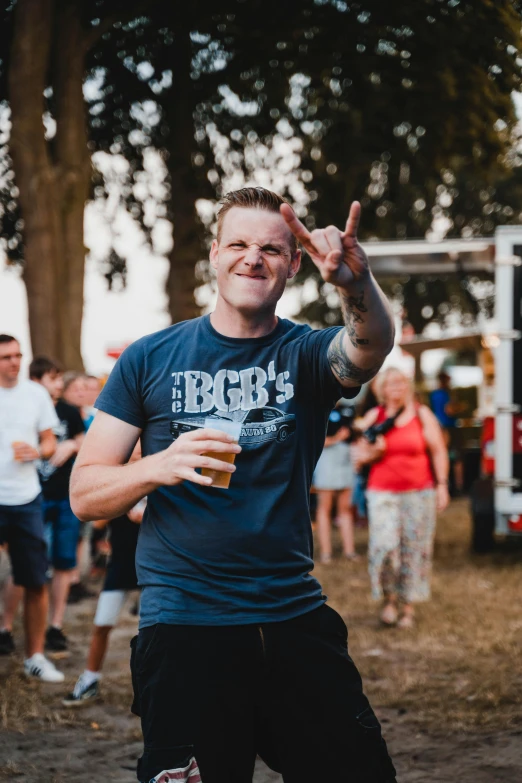 a man standing in front of a crowd of people, inspired by Brian 'Chippy' Dugan, happening, beer in hand, festival vibes, almost smiling, profile image