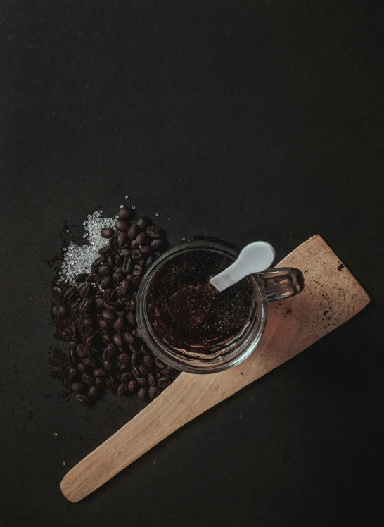 a jar of coffee sitting on top of a wooden spoon, detailed product image, a salt&pepper goatee, dark vibe, jakarta