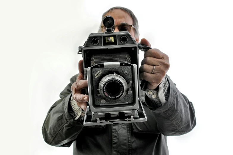 a man taking a picture with an old camera, inspired by Gordon Parks, his whole head fits in the frame, 2022 photograph, rj palmer, ap photography