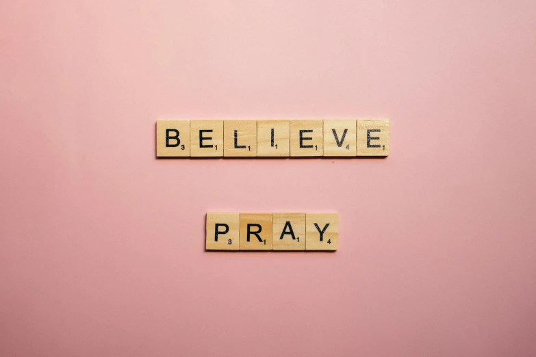 scrabbles spelling believe and pray on a pink background, pexels, 1 6 x 1 6, fan favorite, messages, holy place