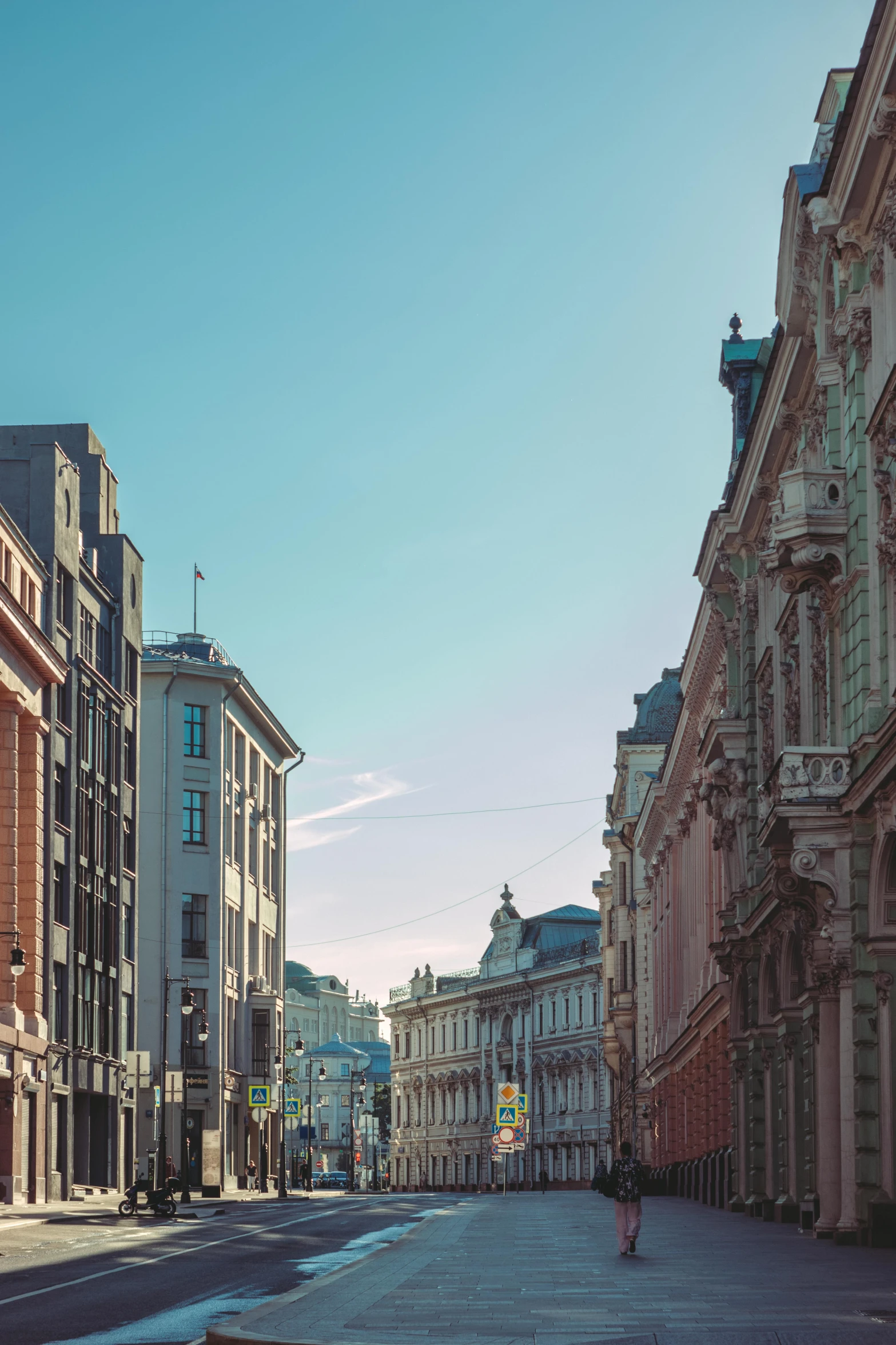 a red fire hydrant sitting on the side of a road, a photo, inspired by Carl Spitzweg, pexels contest winner, neoclassicism, tenement buildings, helsinki, looking from slightly below, pastel hues