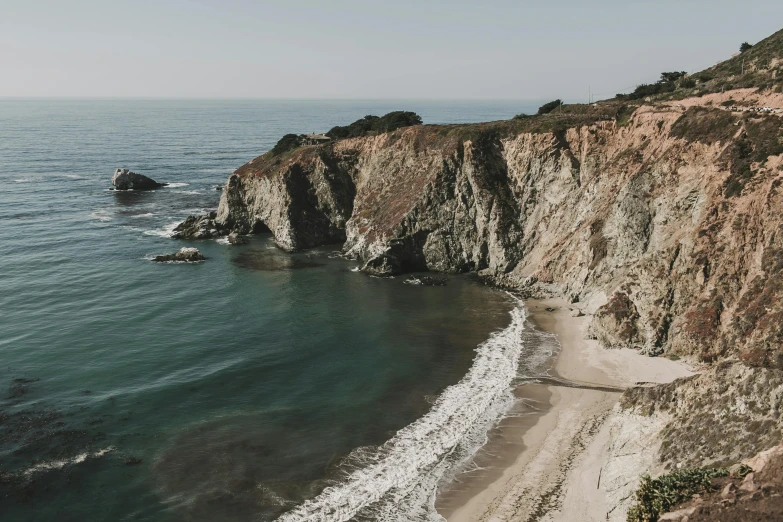 a beach next to a cliff and a body of water, pexels contest winner, central california, 2 5 6 x 2 5 6 pixels, grey, brown