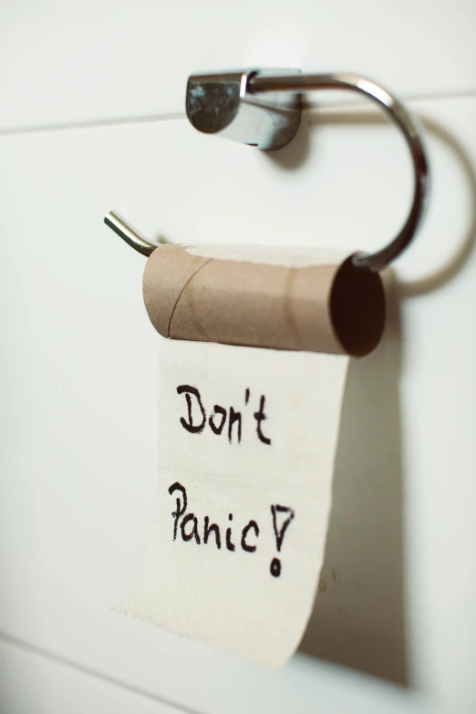 a roll of toilet paper with the words don't panic written on it, pexels, hanging, stick poke, parental advisory, upset