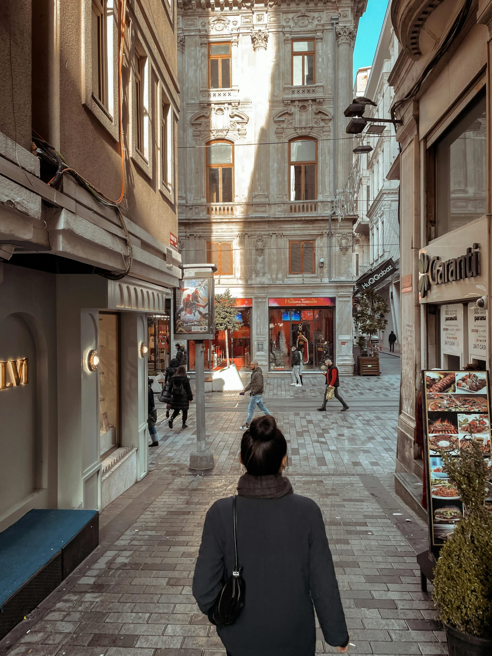 a woman walking down a narrow city street, pexels contest winner, hyperrealism, istanbul, lots of shops, view from inside, late afternoon