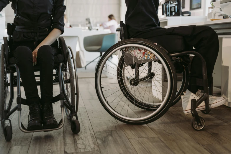 a couple of people that are in a wheel chair, trending on pexels, hurufiyya, sitting on a desk, sharply detailed, worksafe. instagram photo, standing up