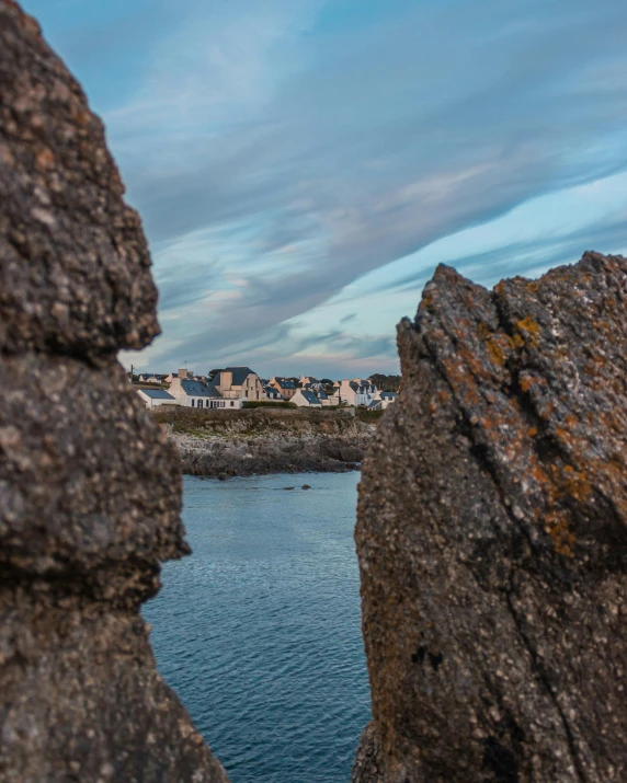 a couple of rocks sitting on top of a body of water, happening, medieval coastal village, trending photo, shot on sony a 7, rock walls