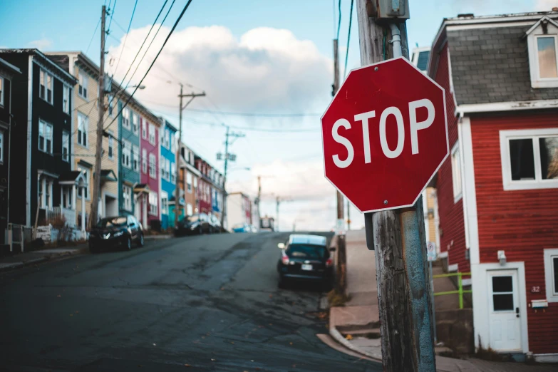 a red stop sign sitting on the side of a road, a photo, by Julia Pishtar, trending on pexels, graffiti, busy small town street, coastal, 🦩🪐🐞👩🏻🦳, gray