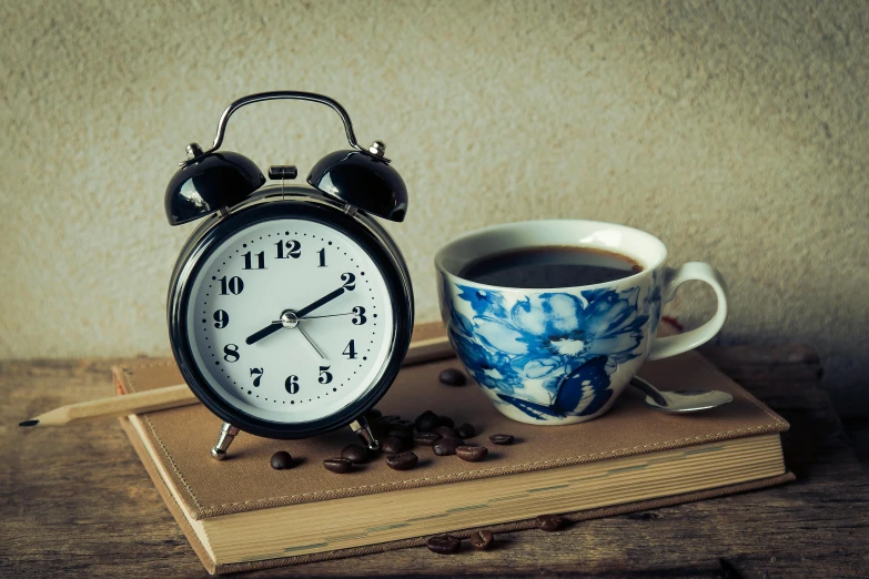 an alarm clock sitting on top of a book next to a cup of coffee, square, blue, thumbnail, homemade