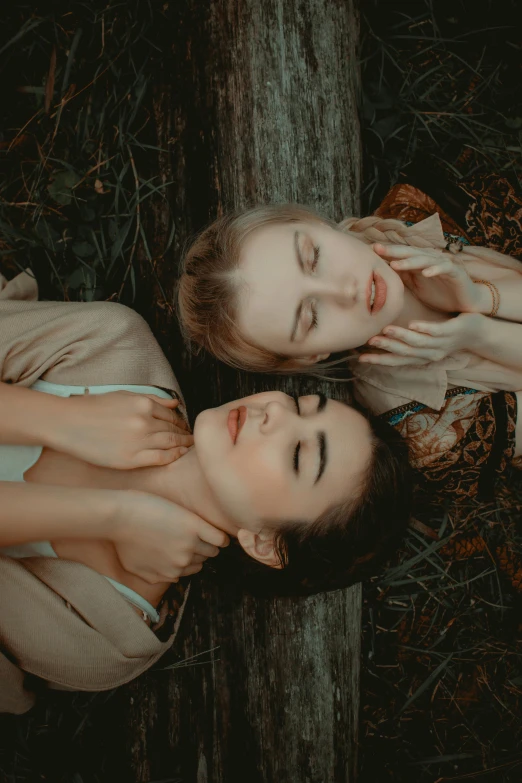 two women laying on the ground next to a tree, by irakli nadar, trending on pexels, aestheticism, pale skin and dark eyes, 15081959 21121991 01012000 4k, arm around her neck, high angle