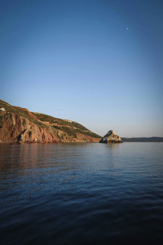 a small island in the middle of a body of water, coastal cliffs, desjarlais, in muted colours, caparisons