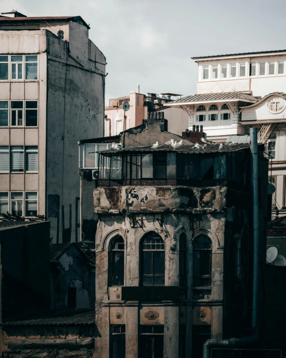 a couple of buildings that are next to each other, inspired by Elsa Bleda, pexels contest winner, brutalism, istanbul, victorian buildings, photo of poor condition, destroyed human structures