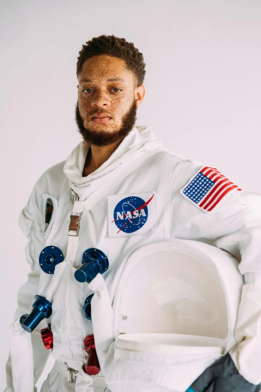 a man in an astronaut suit posing for a picture, by Winona Nelson, pete davidson, ( ( dark skin ) ), white uniform, dustin lefevre