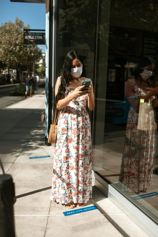 a woman wearing a face mask looking at her phone, reddit, happening, wearing a flowing sundress, sf, square, media photo