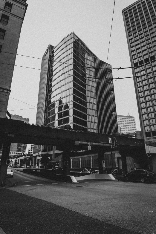 a black and white photo of a city street, inspired by Thomas Struth, unsplash, pittsburgh, monorail, office building, 1 9 8 0 s photo