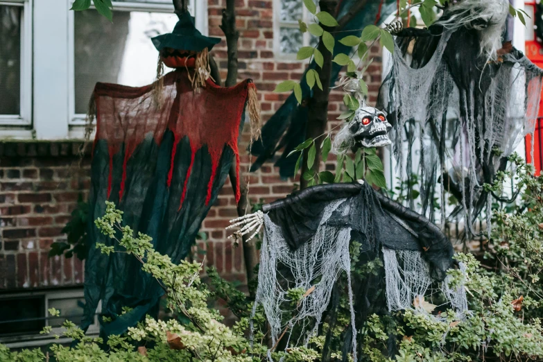 halloween decorations hanging from a tree in front of a house, pexels contest winner, visual art, green and red plants, menacing statues, flying mythical beasts, mysterious exterior