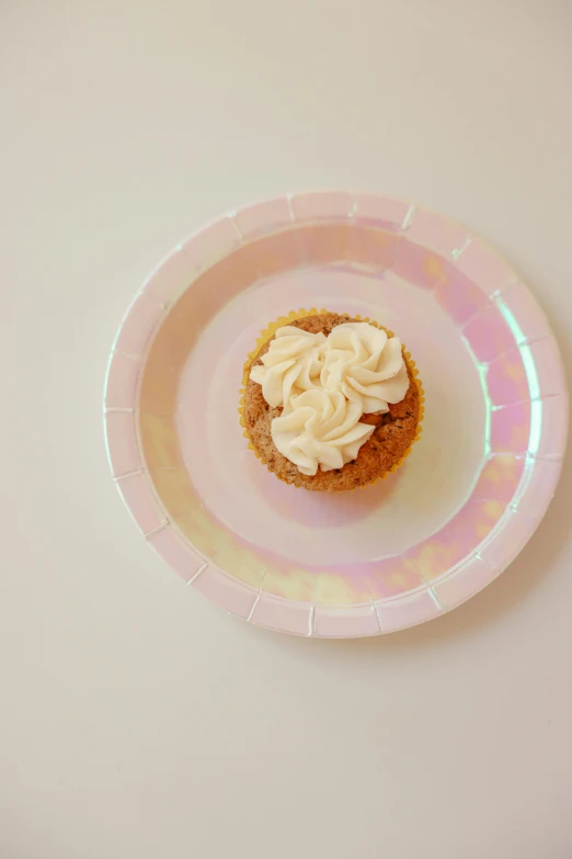 a cupcake sitting on top of a pink plate, mother of pearl iridescent, blonde cream, :6, caramel